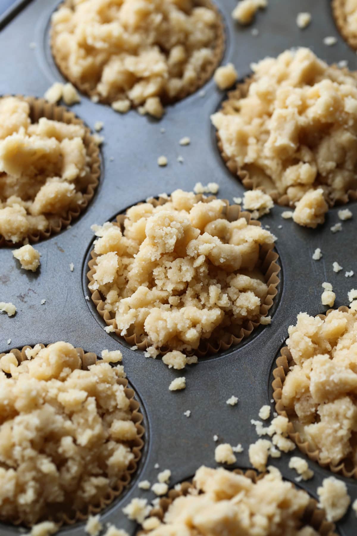 crumb topping on banana muffins before being baked in a muffin tin