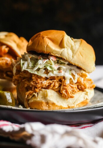 A shredded BBQ Chicken sandwich on a bun with cole slaw