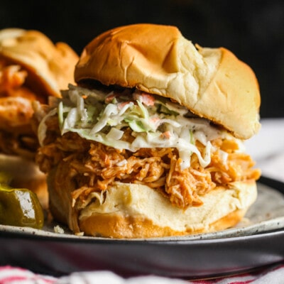 A shredded BBQ Chicken sandwich on a bun with cole slaw