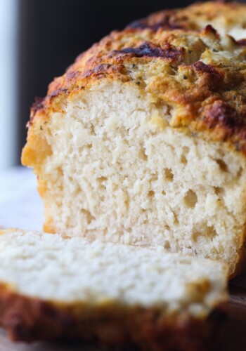 A loaf of Ranch Beer Bread with a slice cut off.