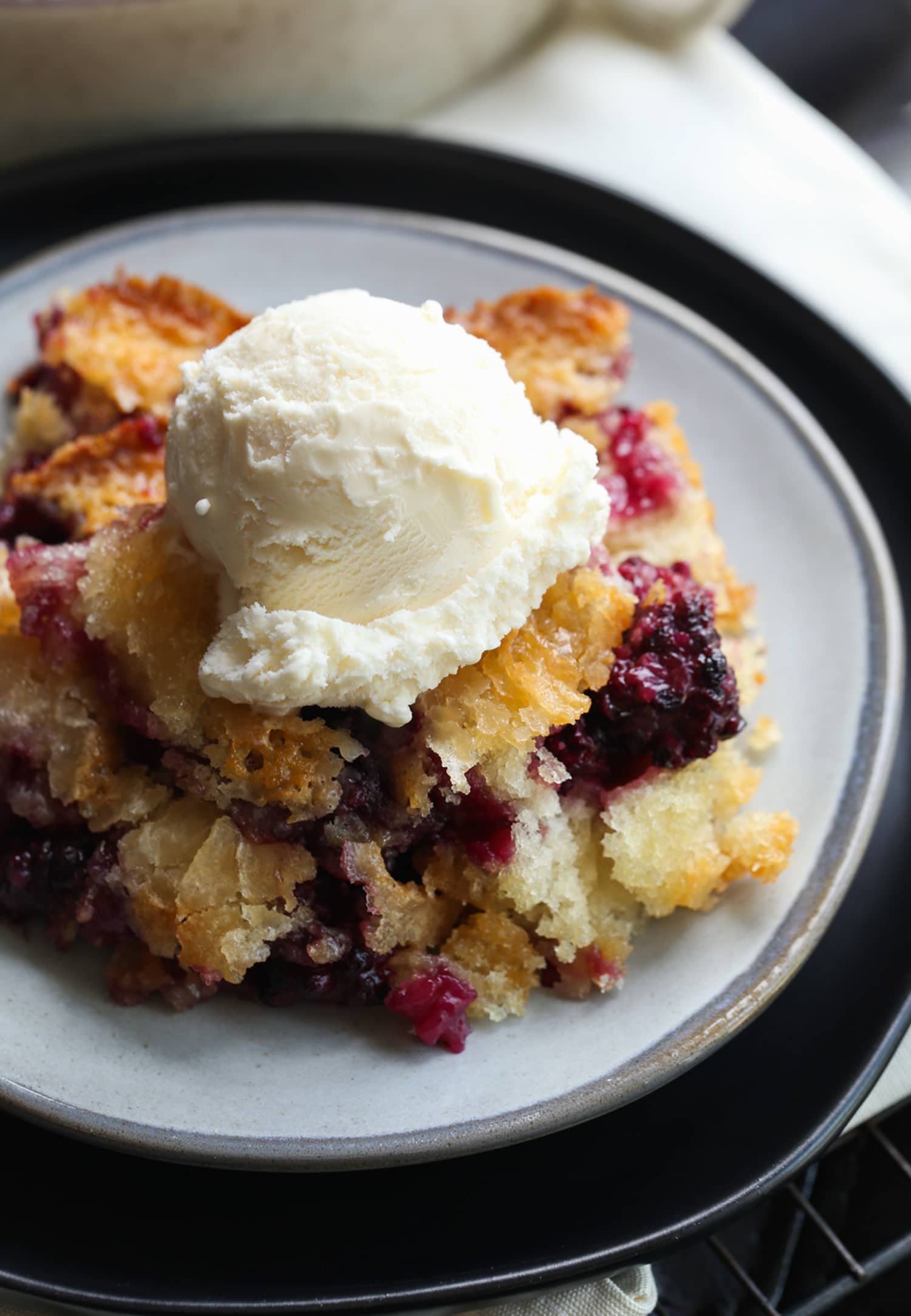 Blackberry cobbler on a plate with vanilla ice cream