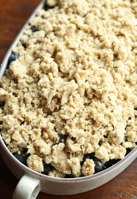 Crumble topping on top of blueberries in a baking dish