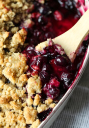 Blueberry Crisp in a baking dish with a spoon to serve