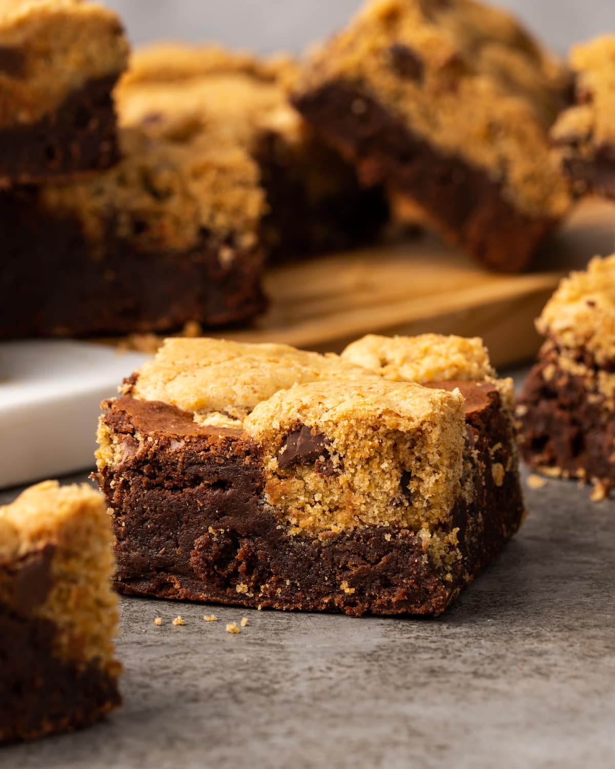 A brownie cookie on a countertop surrounded by more brookies in the background.