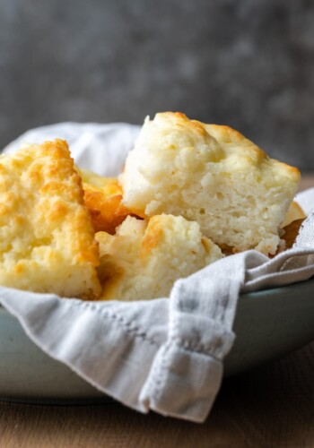 Butter swim biscuits in a serving bowl lined with a cloth.