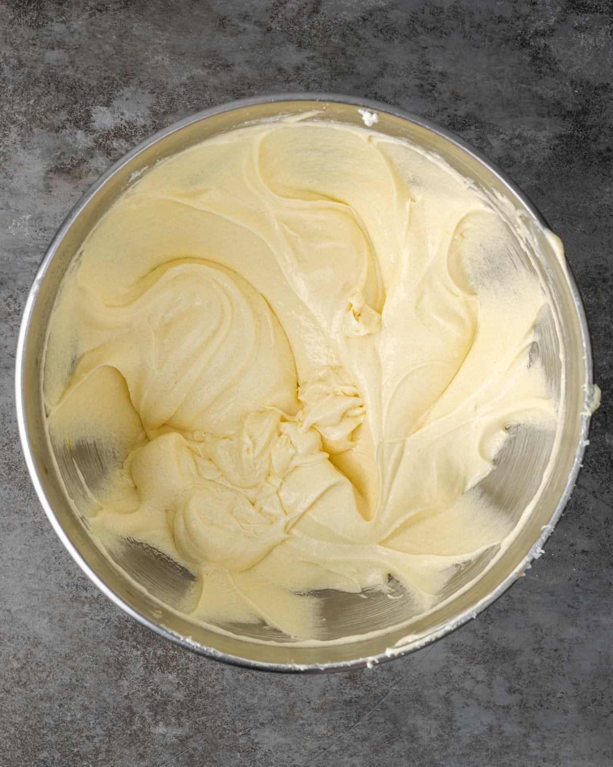 Cannoli cake batter in a metal mixing bowl.