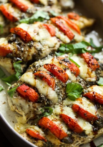 Caprese Chicken in a baking dish garnished with basil