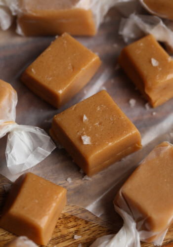 Freshly cut caramel pieces set out on wax paper, waiting to be sprinkled with sea salt and wrapped.