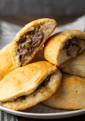 Philly cheesesteak stuffed biscuits in a pile on a plate.