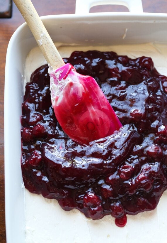 spreading cherry filling onto whipped cream