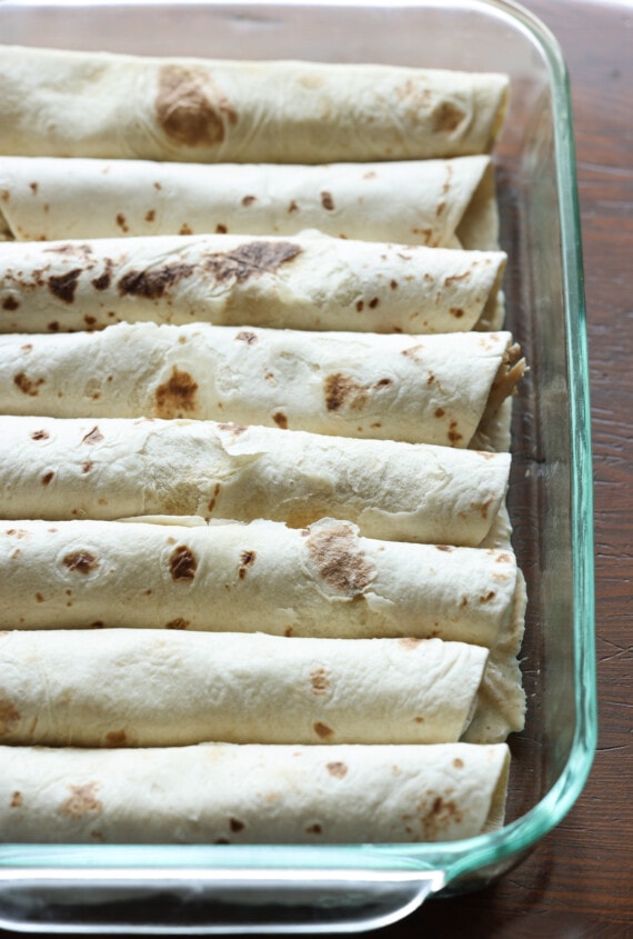 rolled up tortillas in a baking dish filled with chicken