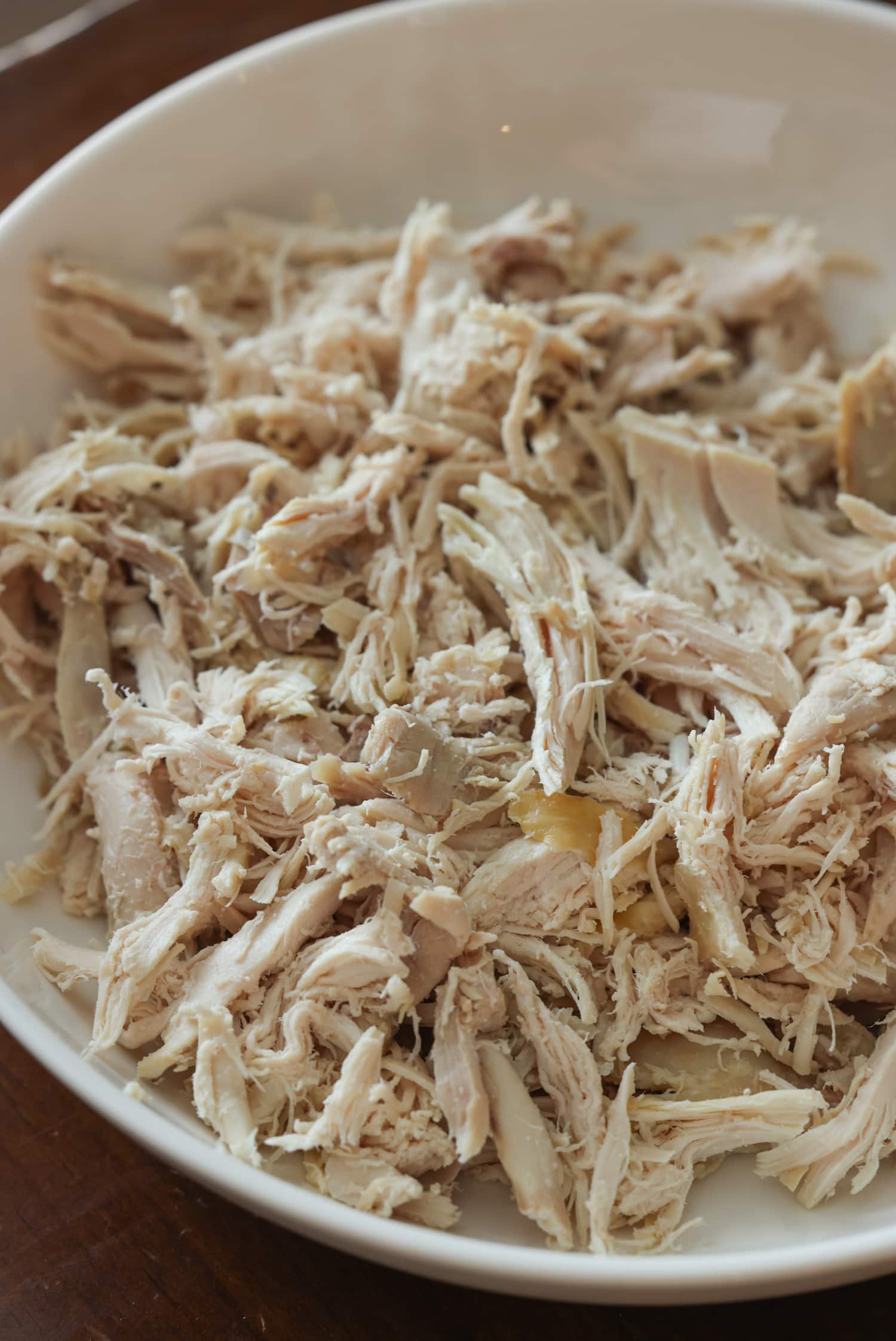 shredded rotisserie chicken in a white bowl