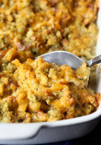 A spoon scoops Chicken Cordon Bleu Casserole from a baking dish.