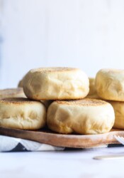 Homemade English muffins stacked on a plate