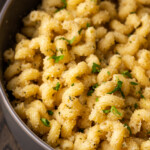 Close up of garlic bread pasta in a pot.