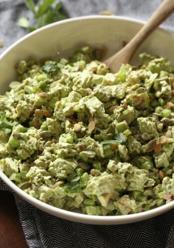 Green goddess chicken salad in a large bowl with a wooden spoon.