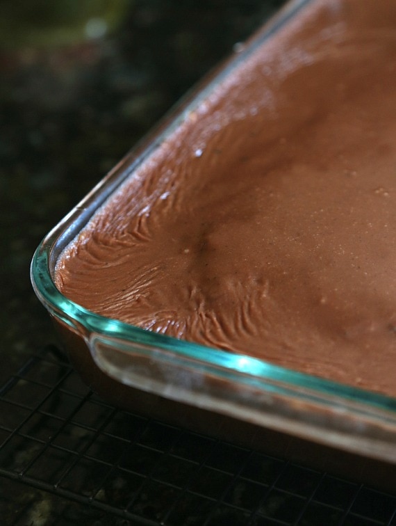 Letting the poured frosting set on the zucchini cake