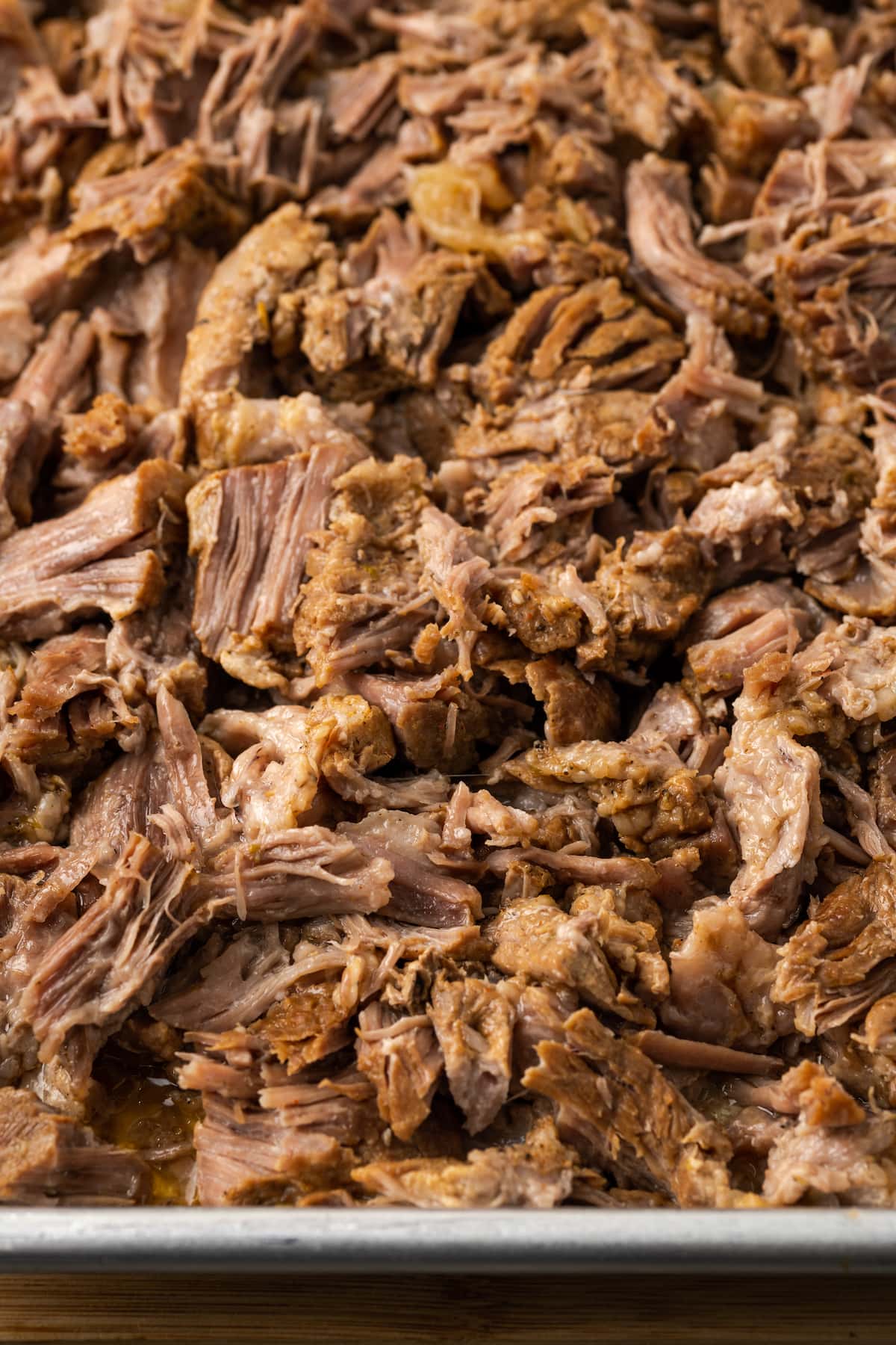 Shredded pork on a metal baking sheet.