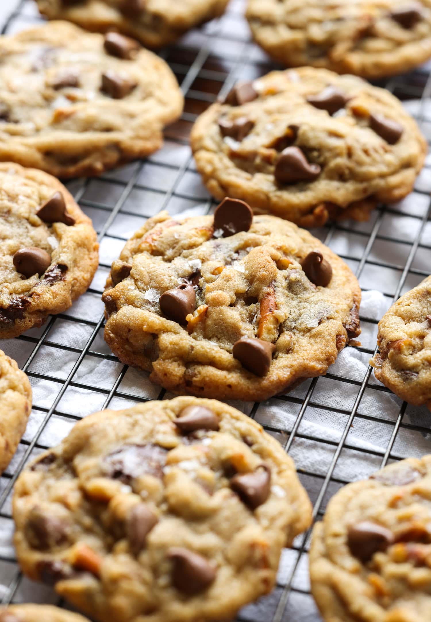 Kitchen Sink Cookies with pretzels and chocolate chips on top on a wire cooling rack