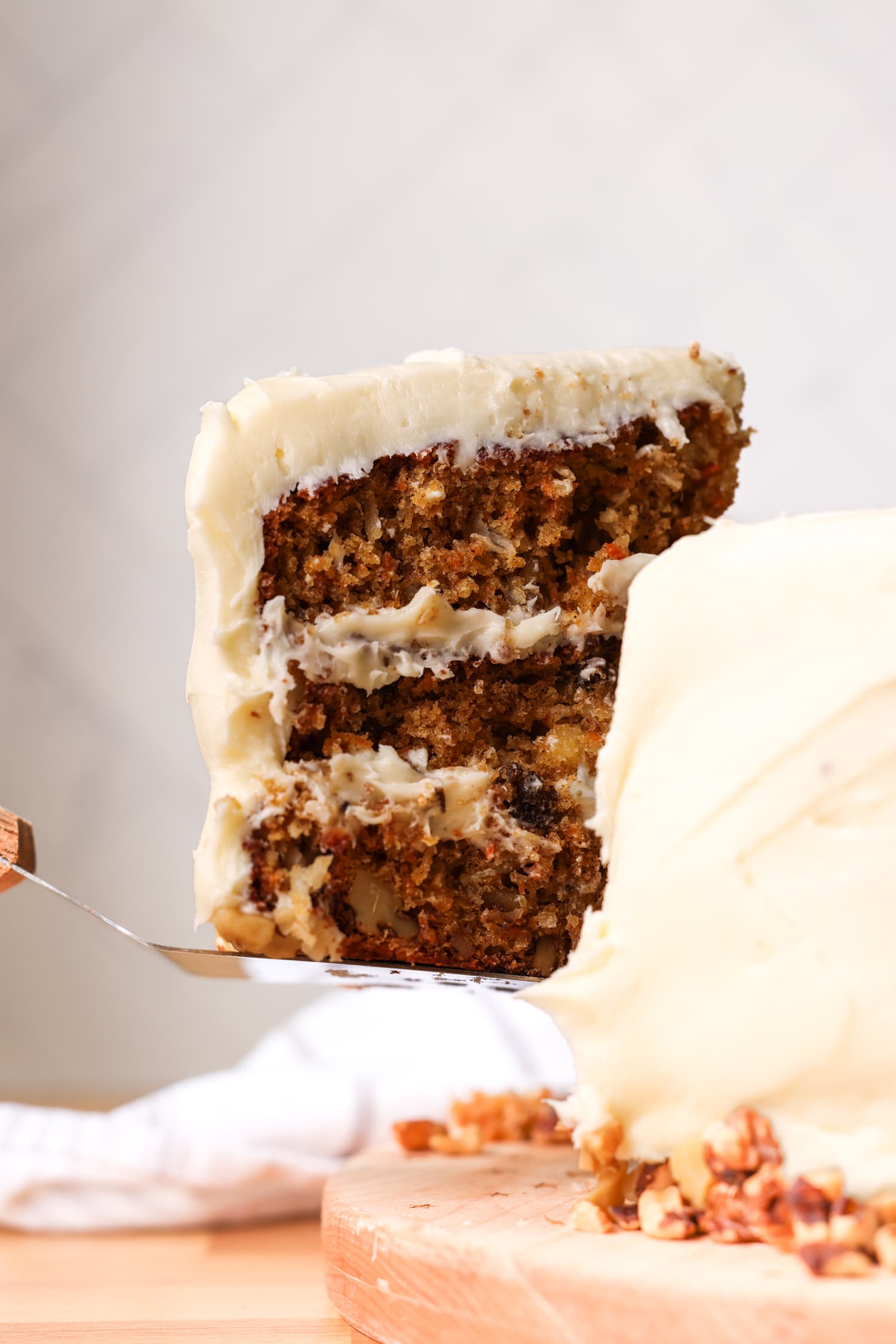 lifting a piece of carrot cake off of a cake plate