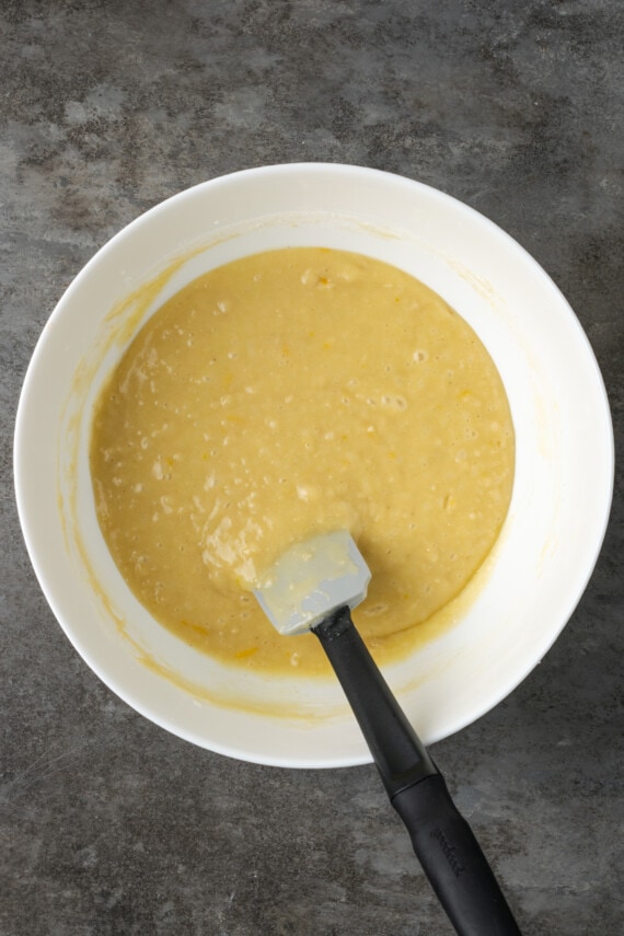 Lemon pound cake batter in a white bowl with a spatula.