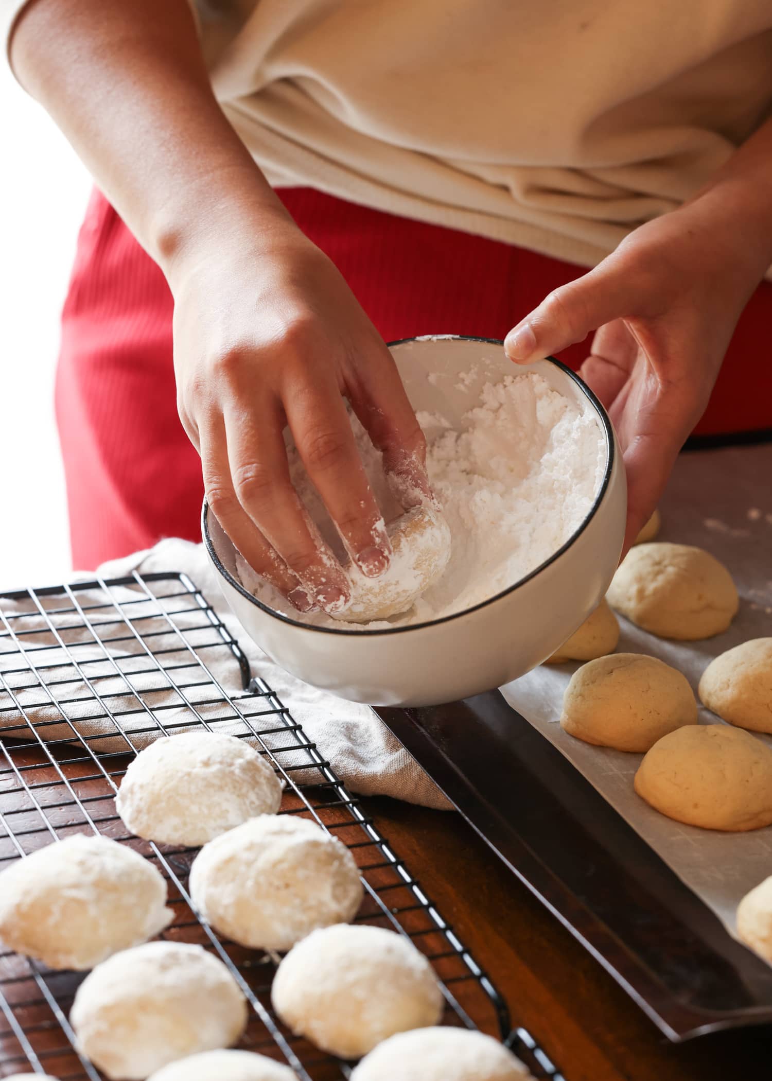 coating a lemon cookie in powdered sugar