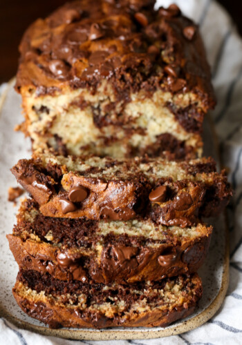 A loaf of chocolate marbled banana bread sliced to reveal the marbled interior.