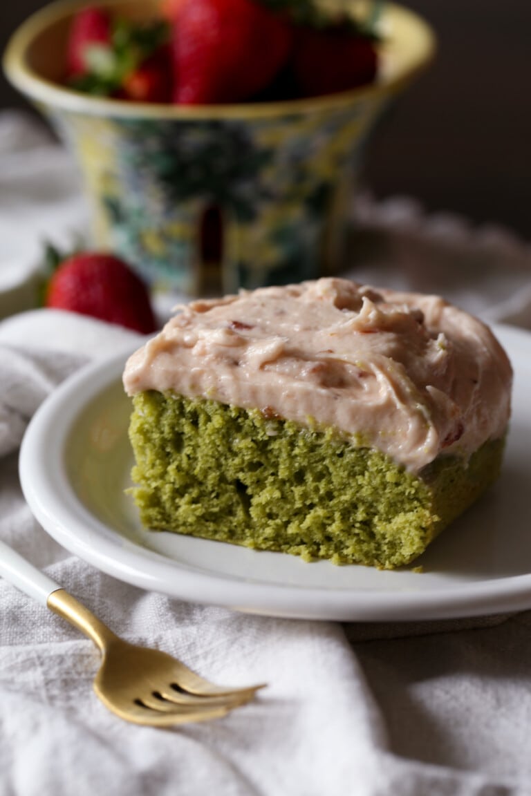 slice of matcha cake with strawberry frosting