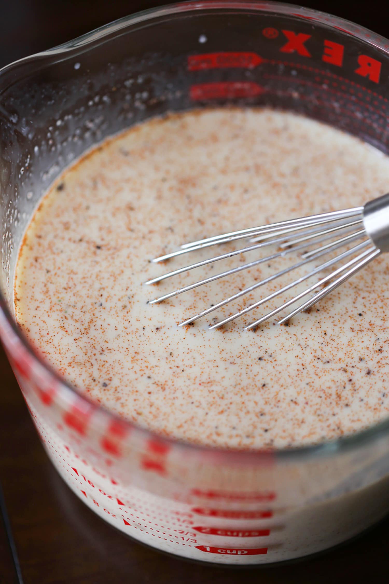 Whisked milk and spices in a measuring cup