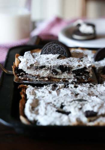 serving Oreo Slab Cheesecake with a spatula