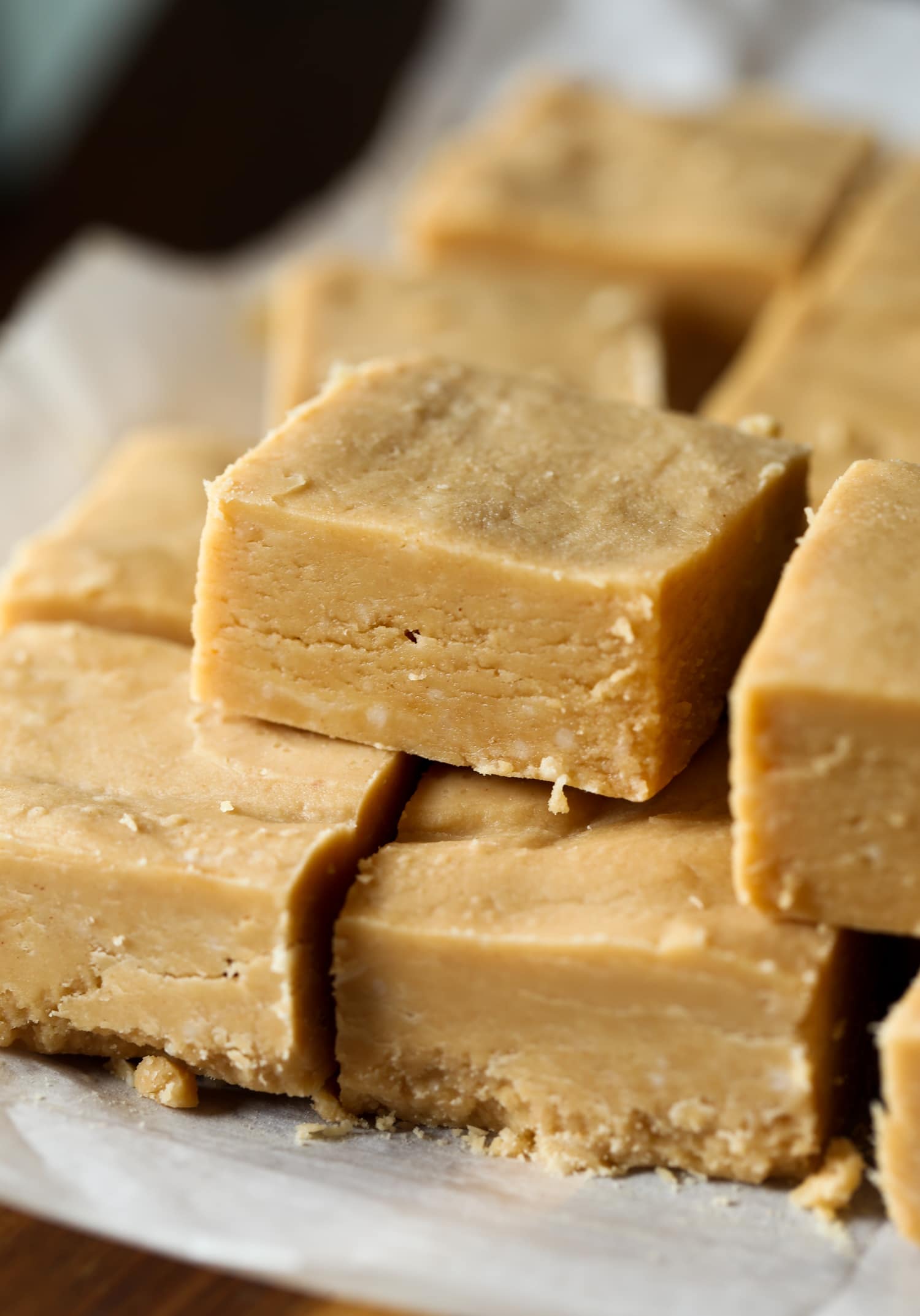 Peanut butter fudge squares stacked on top of each other.