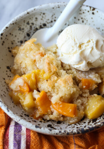 Homemade peach cobbler served with vanilla ice cream.