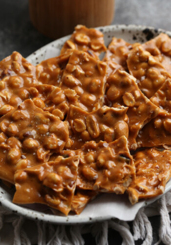 Golden, caramelized homemade peanut brittle served on a plate.