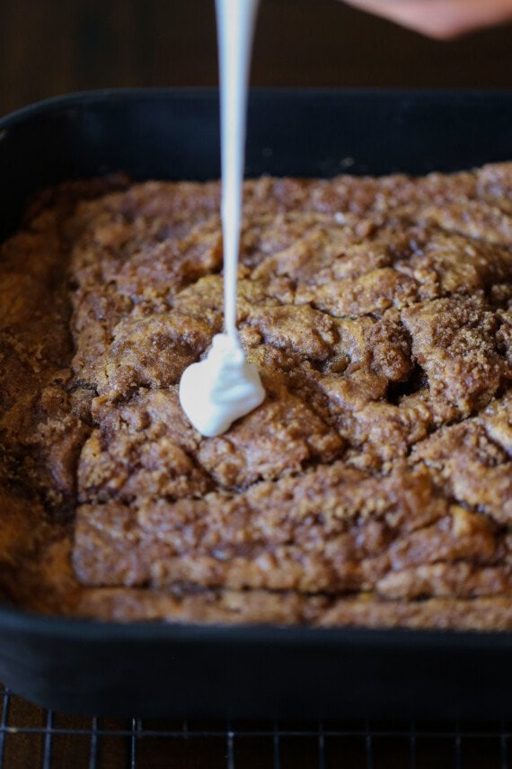 drizzling icing on top of pumpkin cake