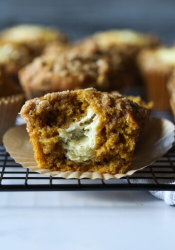 Pumpkin muffin broken in half with cream cheese filling