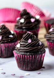 Chocolate cupcakes frosted with a rich and decadent chocolate fudge buttercream frosting, topped with sprinkles.