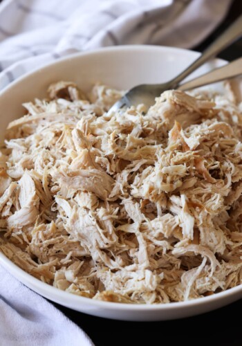 Shredded chicken breast in a bowl with forks