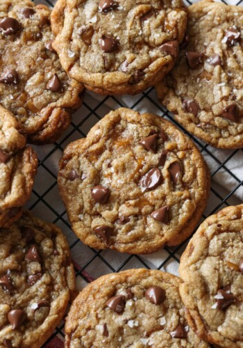 butter crunch chocolate chip cookies on a wire rack with flaked sea salt